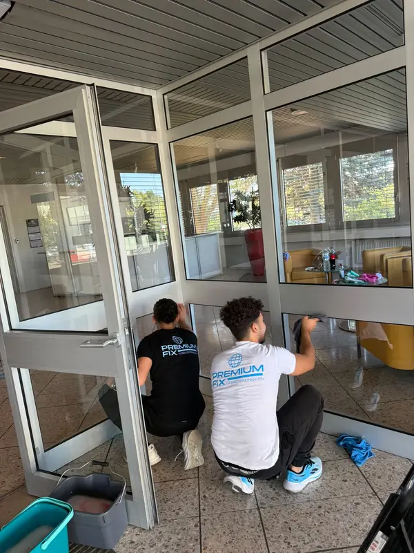 PremiumFix Team bei der Reinigung der Glasfront im Eingangsbereich